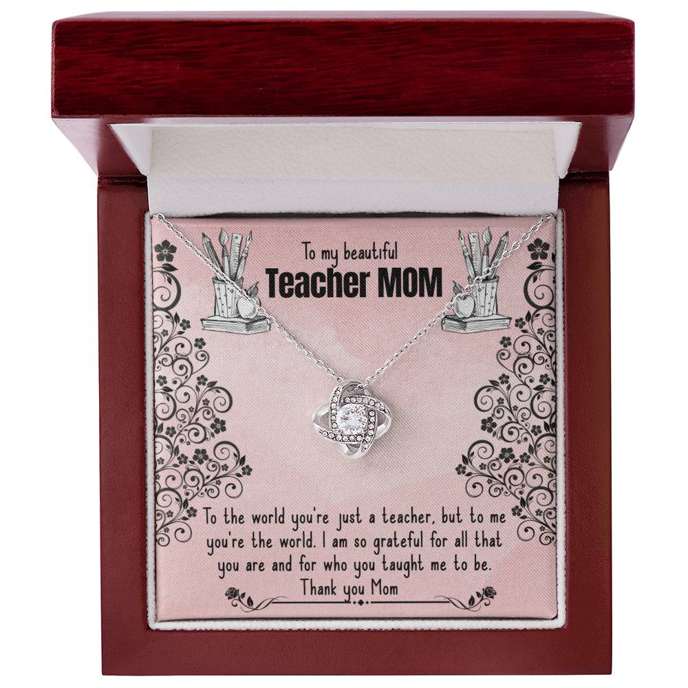 An open jewelry gift box containing a To My Beautiful Teacher MOM, To The World You're Just A Teacher - Love Knot Necklace with cubic zirconia crystals and an adjustable chain, accompanied by an inscription card addressed to a "teacher mom," expressing gratitude and love from ShineOn Fulfillment.