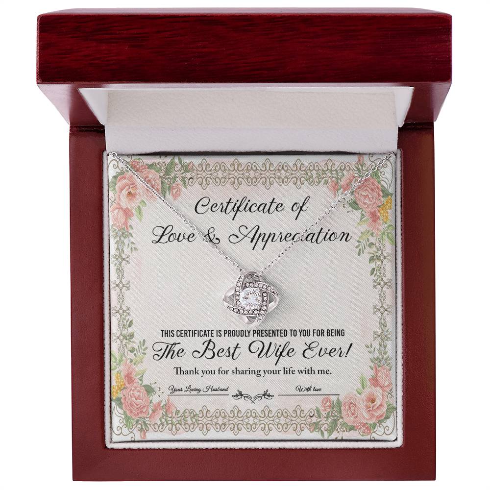 The "To Wife, Love & Appreciation - Love Knot Necklace" features a heart-shaped pendant elegantly displayed over a "Certificate of Love & Appreciation," expressing gratitude for being "The Best Wife Ever!" The necklace showcases a gold finish with sparkling cubic zirconia crystals, and the certificate is beautifully adorned with floral borders.