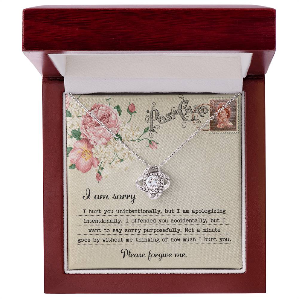 The "Sorry-Apologizing Intentionally - Love Knot Necklace," featuring a 14k white gold intertwined heart pendant, is beautifully presented on a card with a floral design that includes an apology note expressing heartfelt remorse and asking for forgiveness.