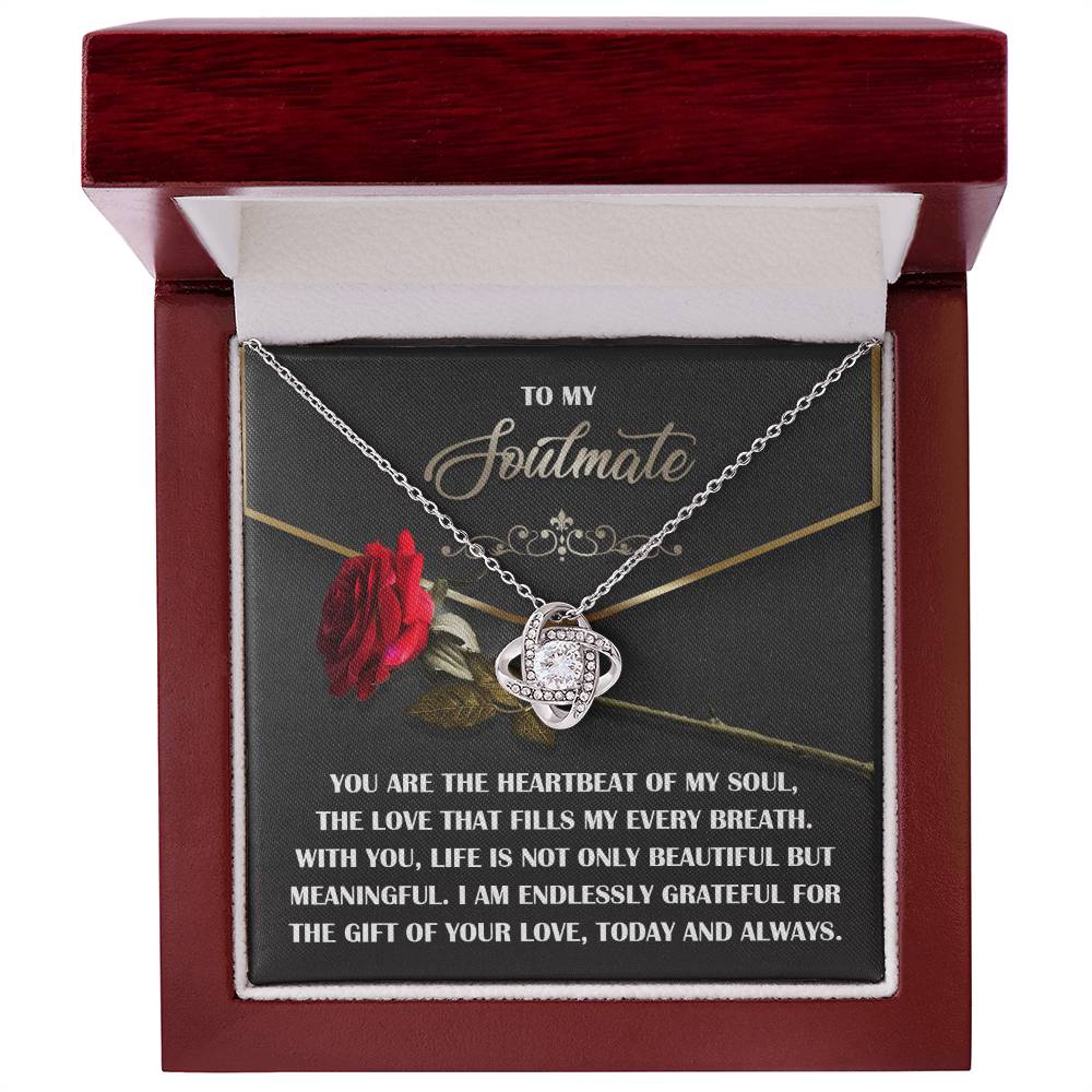 The Soulmate-My Every Breath - Love Knot Necklace, featuring a silver pendant, is elegantly showcased in an open jewelry box. The box cover reads "To my soulmate" with a heartfelt message and displays a red rose graphic, symbolizing our unbreakable bond.