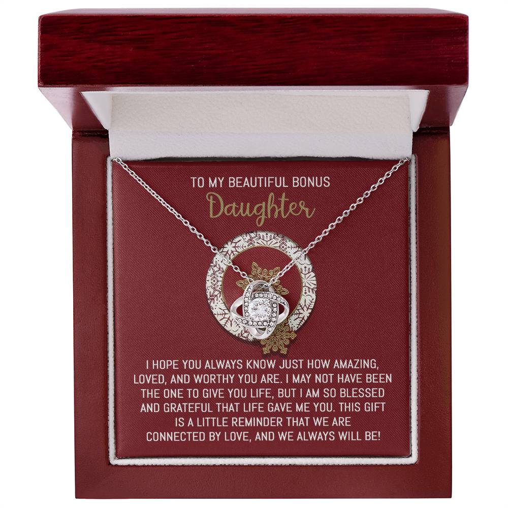 The Bonus Daughter-Always Will Be - Love Knot Necklace, elegantly displayed in a box embellished with cubic zirconia crystals, is the perfect way to express love and gratitude to your "bonus daughter," making it the ultimate personalized gift.