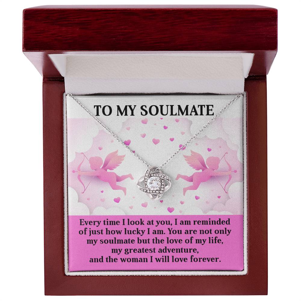 The Soulmate-Greatest Adventure Love Knot Necklace boasts an intertwined ring pendant with cubic zirconia crystals, elegantly boxed with a romantic message about love and gratitude set against pink cherubs and heart graphics, making it an ideal personalized gift.