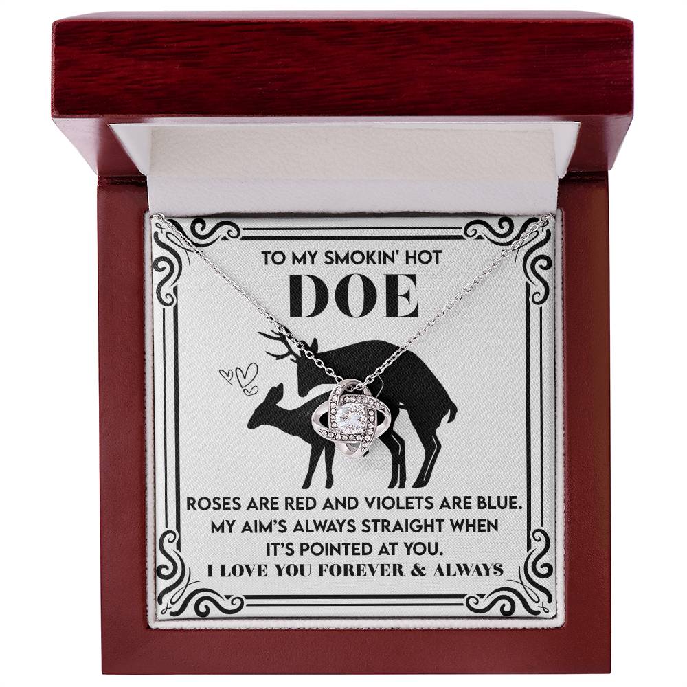 The Soulmate-Pointed At You Love Knot Necklace with a white gold finish rests in a deer-themed box, featuring shimmering cubic zirconia crystals and a romantic poem for "Doe.