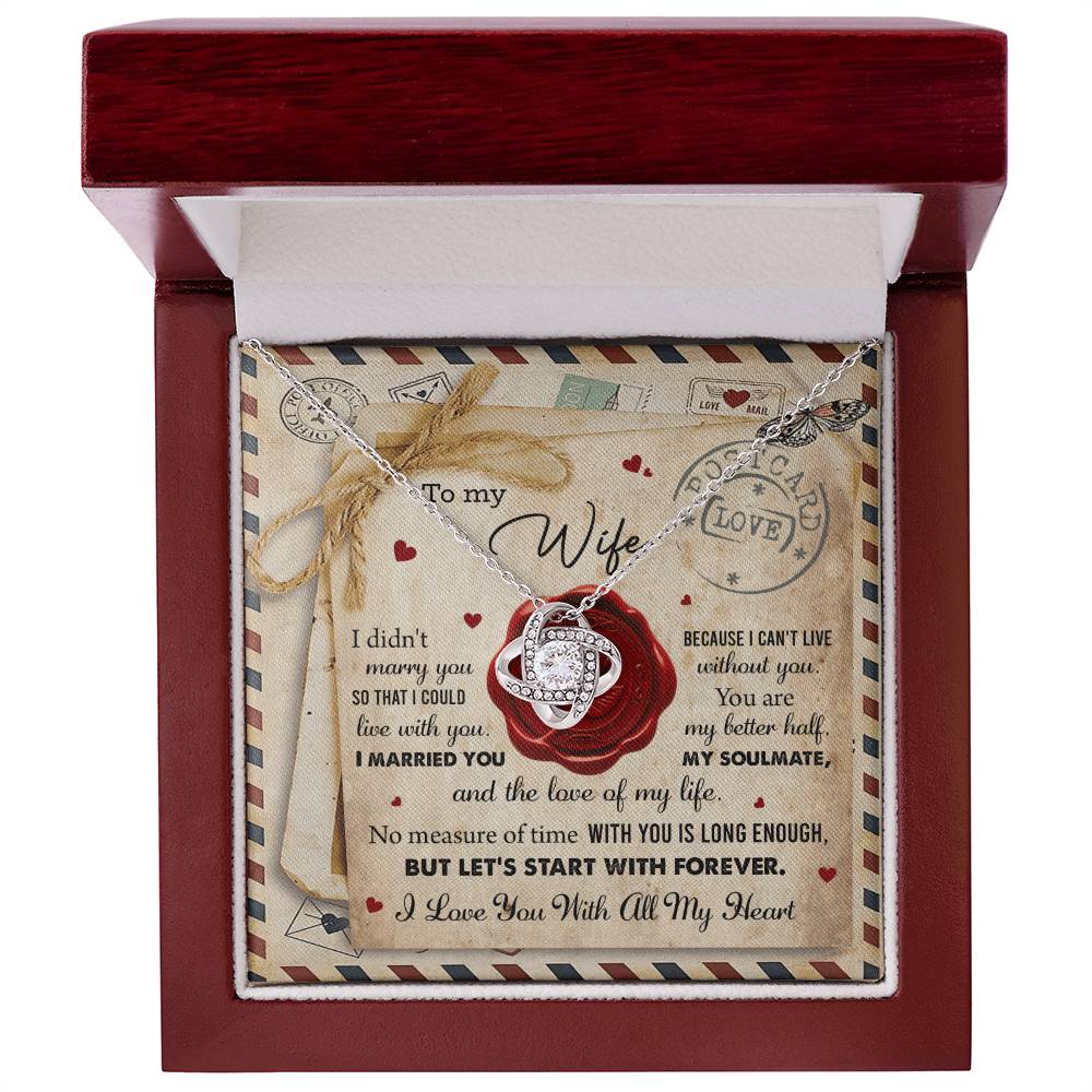 A "To Wife, Marry You - Love Knot Necklace" with an interlocking rings pendant, adorned with cubic zirconia crystals, displayed in a box featuring the background design of a love letter. The letter includes heartfelt messages for a wife, expressing love and commitment—a perfect personalized gift.