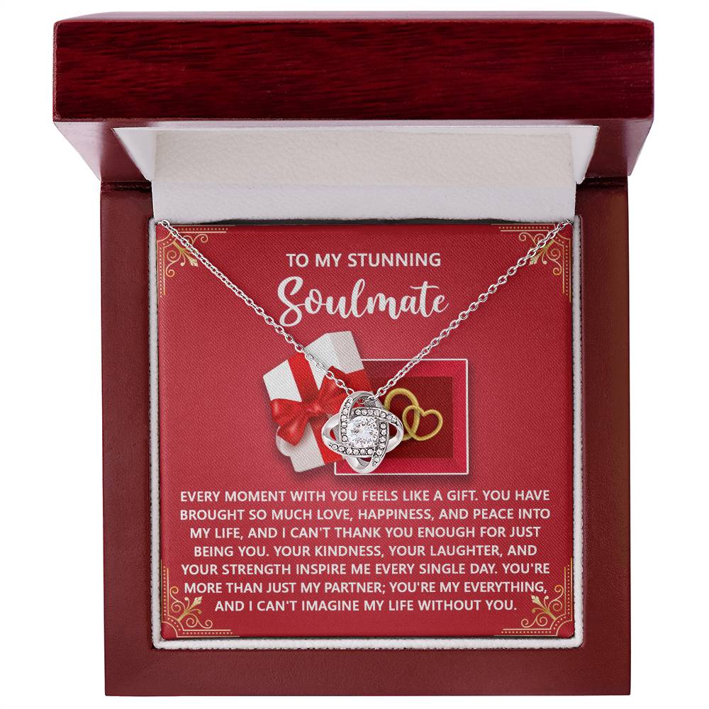 The Soulmate-Like A Gift - Love Knot Necklace, featuring a heart and infinity pendant with cubic zirconia, is beautifully presented in an open red gift box. It comes with a touching message for your soulmate, making it the perfect personalized gift.