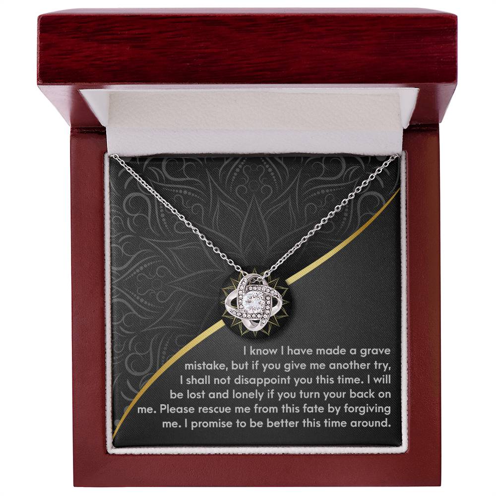 The "Sorry-Turn Your Back - Love Knot Necklace" features a heart-shaped pendant adorned with cubic zirconia crystals and comes in a red gift box. The lid of the box bears an inscribed message expressing regret and seeking forgiveness.