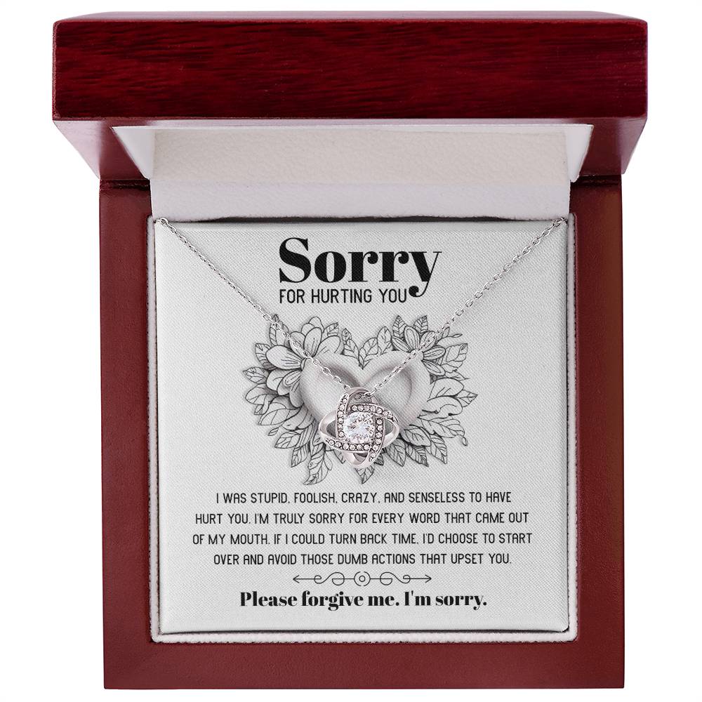 The Sorry-Turn Back Time - Love Knot Necklace, adorned with sparkling cubic zirconia crystals and featuring an intertwined pendant, is displayed on a card with the heartfelt apology message, "Sorry for hurting you," symbolizing an unbreakable bond and a request for forgiveness.