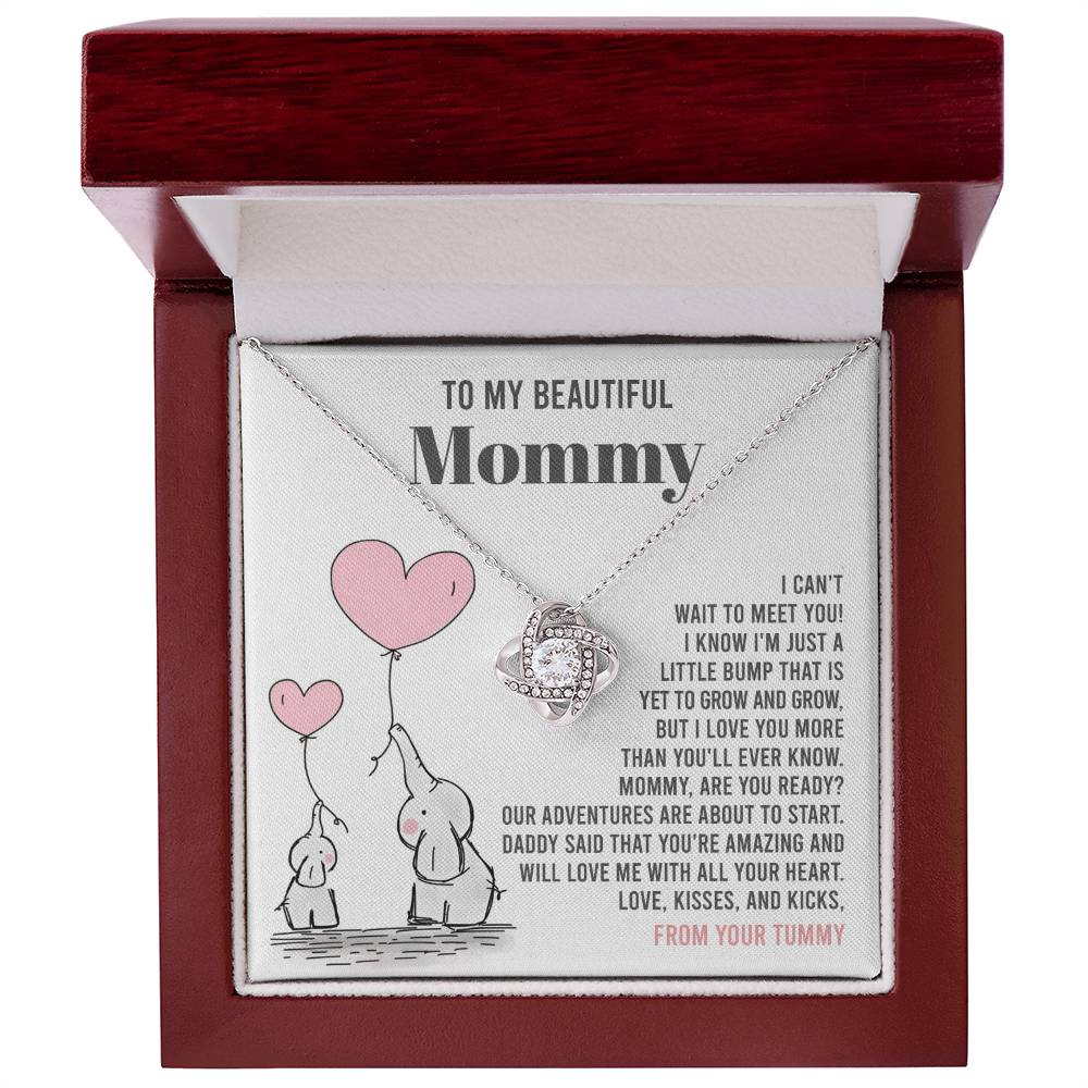 A personalized gift featuring the "To Mama To Be, All Your Heart" - Love Knot Necklace pendant necklace in a gift box with a sentimental message for "mommy" from an unborn child, highlighted by a captivating cubic zirconia centerpiece from ShineOn Fulfillment.