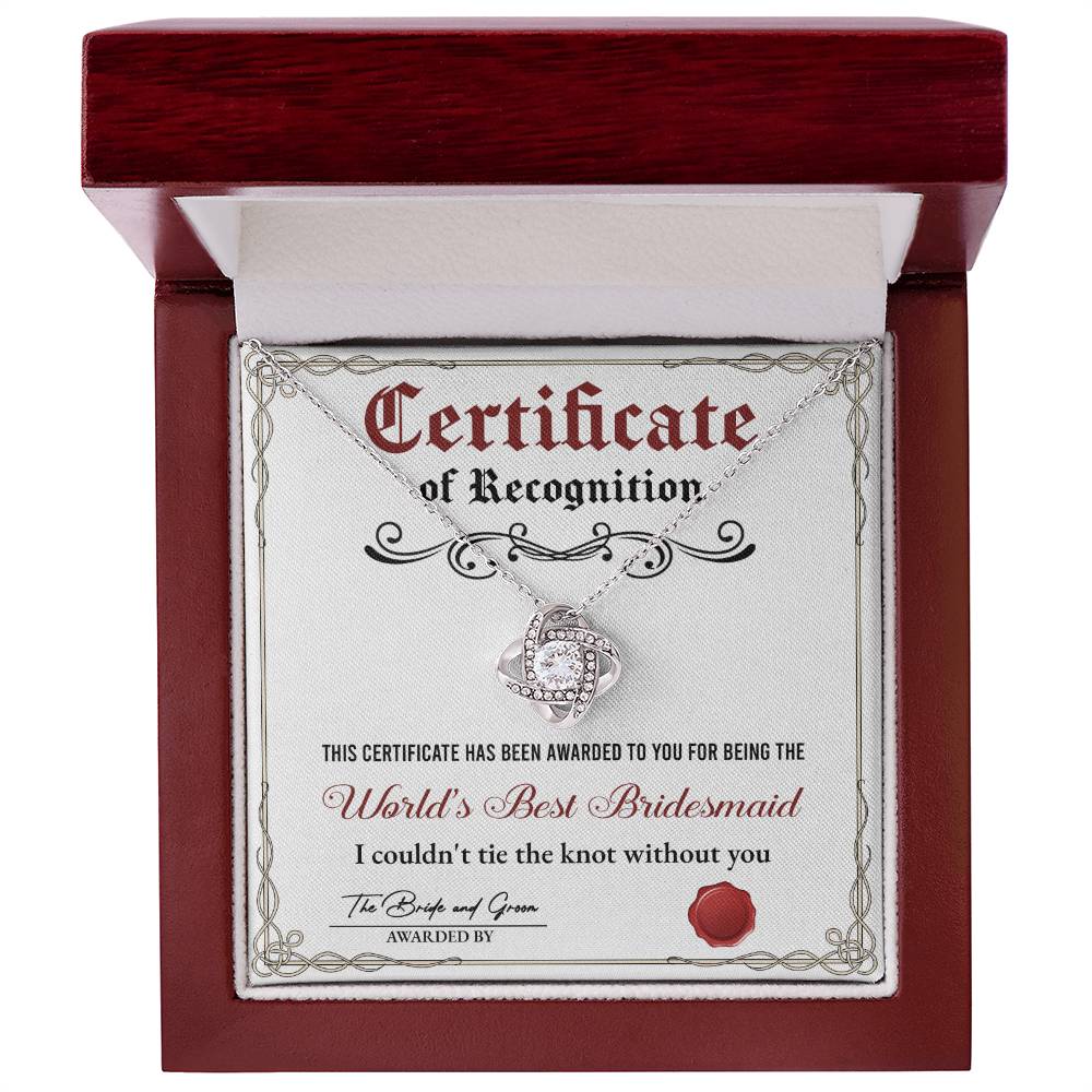 A stunning To Bridesmaid, Certificate Of Recognition - Love Knot Necklace in 14k white gold, adorned with cubic zirconia crystals, is displayed on a certificate that reads "World's Best Bridesmaid" awarded by the bride and groom.