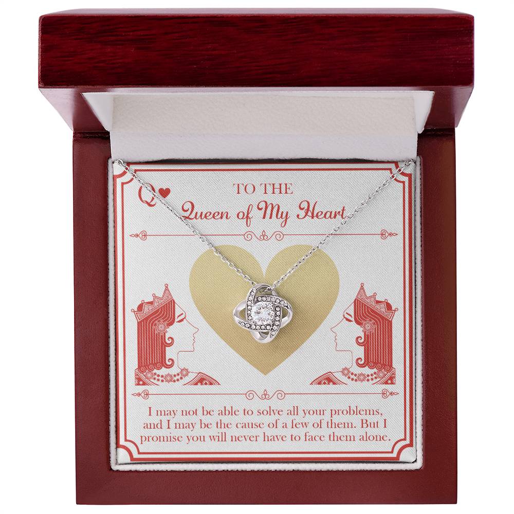 The "To Wife, The Queen - Love Knot Necklace," featuring cubic zirconia crystals, is beautifully presented on a card that displays a heart and two queens. The card bears the words "To the Queen of My Heart" along with a heartfelt message underneath.