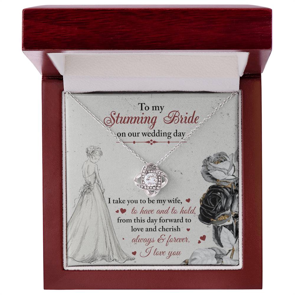 A To My Bride, Be My Wife - Love Knot Necklace with a pendant adorned in cubic zirconia crystals is displayed against a background featuring a bride illustration and a heartfelt wedding message.