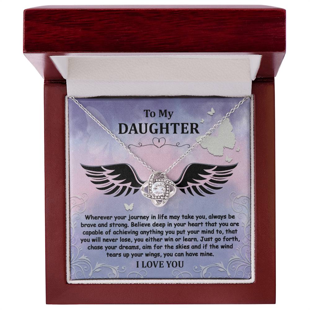 The "To Daughter, Brave And Strong - Love Knot Necklace" features a gold finish and a Cubic Zirconia pendant, beautifully displayed in a box. The box contains a heartfelt message titled "To My Daughter," encouraging bravery, strength, and the pursuit of dreams, and concludes with the words "I LOVE YOU.