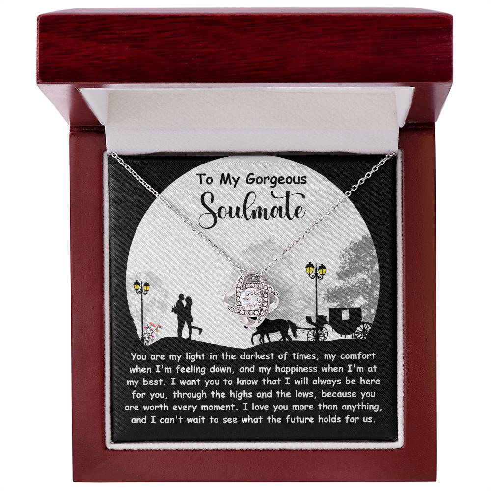 The Soulmate-Holds For Us Love Knot Necklace features a sparkling cubic zirconia pendant in a wooden box, with a romantic couple and horse silhouette background and the message, "To My Gorgeous Soulmate.