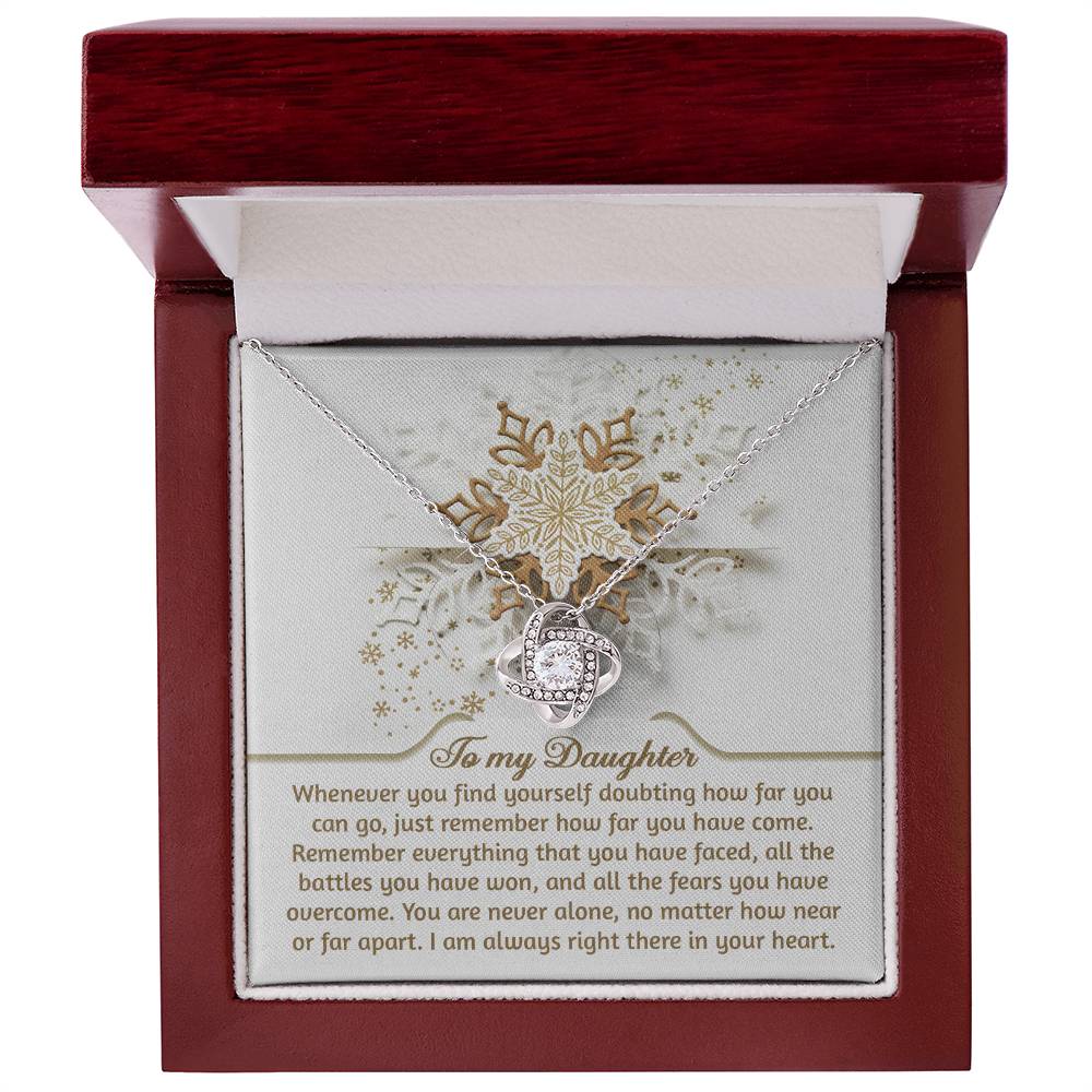 Encased in a wooden box, the Daughter-You Can Go - Love Knot Necklace shines with cubic zirconia crystals. It comes with an inspiring message titled "To my Daughter," representing an unbreakable bond that triumphs over doubts and challenges, whether together or apart.