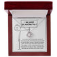 The Sorry-Missing Piece Love Knot Necklace, adorned with cubic zirconia crystals, features a pendant displayed in an open wooden box. Inside the lid is an illustration of a stick figure holding a sign that reads "I am sorry for hurting you." Below it is a heartfelt apology message, making this classic gift a touching symbol of reconciliation.
