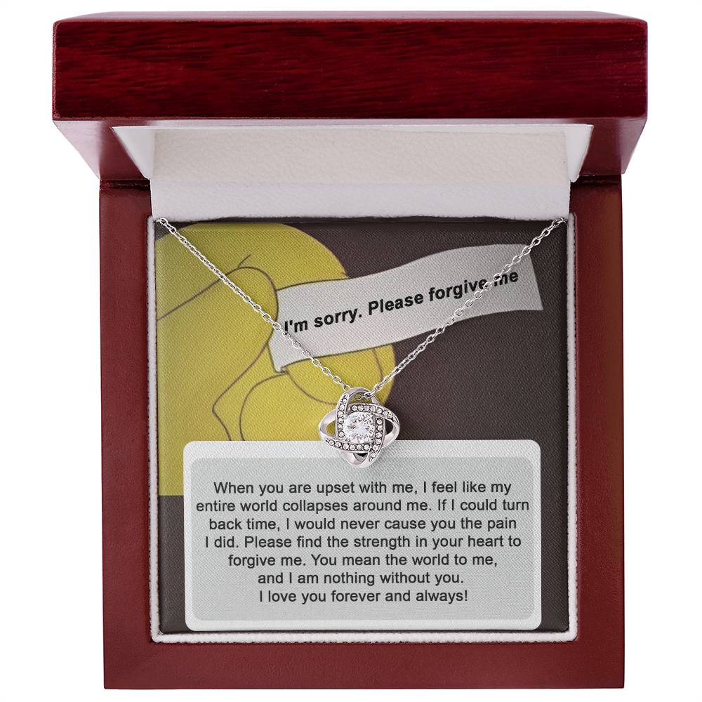 A "Sorry, Nothing Without You" Love Knot Necklace adorned with cubic zirconia crystals is elegantly placed over a card that reads, "When you are upset with me..." and continues with a heartfelt apology and expression of love.