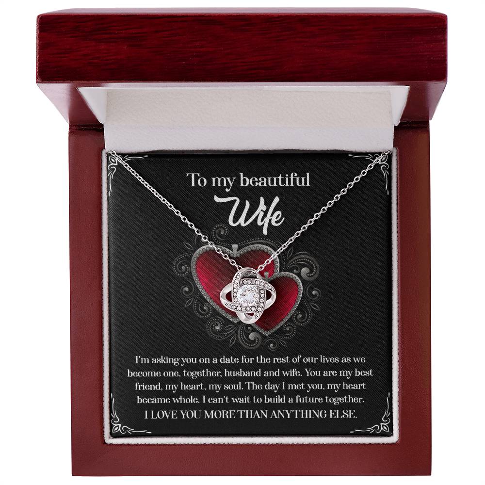 A To Wife, Heart Became Whole - Love Knot Necklace in a gift box, adorned with sparkling cubic zirconia crystals and accompanied by a heartfelt message for a wife, expressing love and a desire to build a future together.