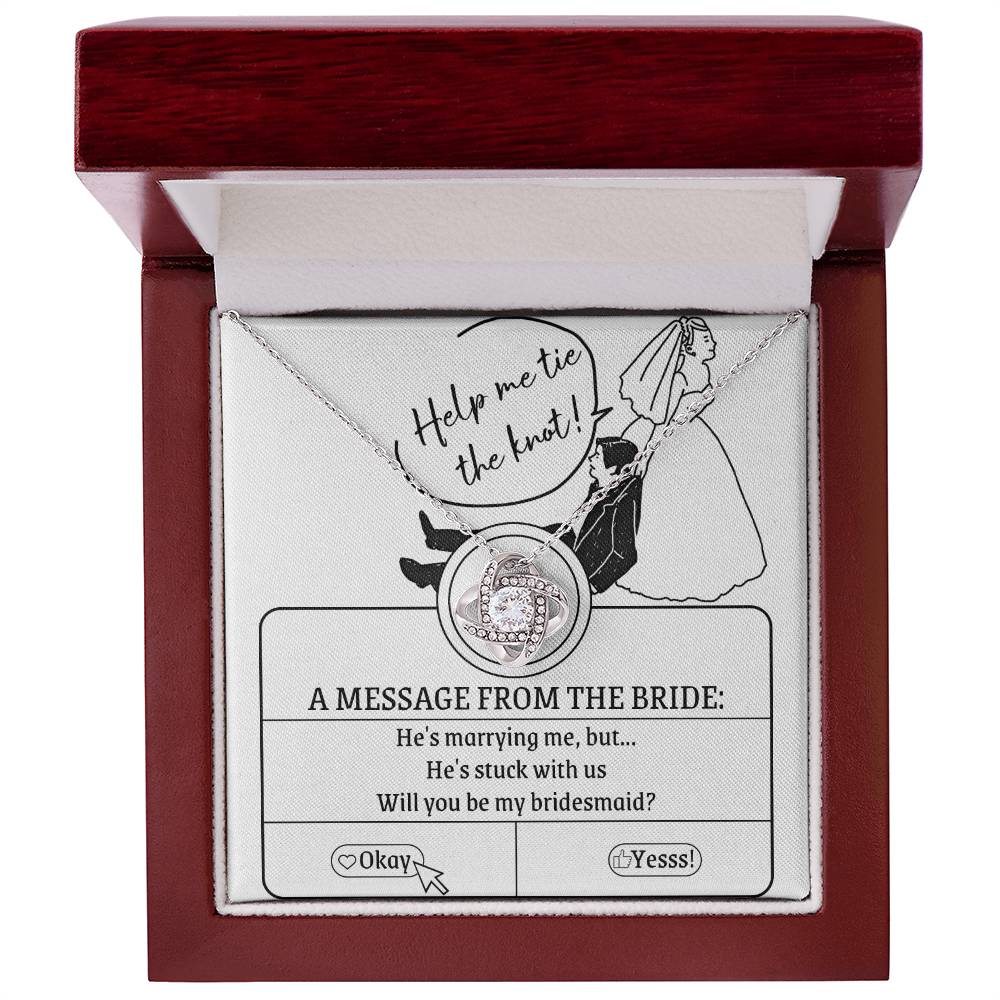 A To My Bridesmaid, Stuck With Us - Love Knot Necklace rests on a card that reads, "Help me tie the knot! A message from the bride: He's marrying me, but... He's stuck with us. Will you be my bridesmaid?