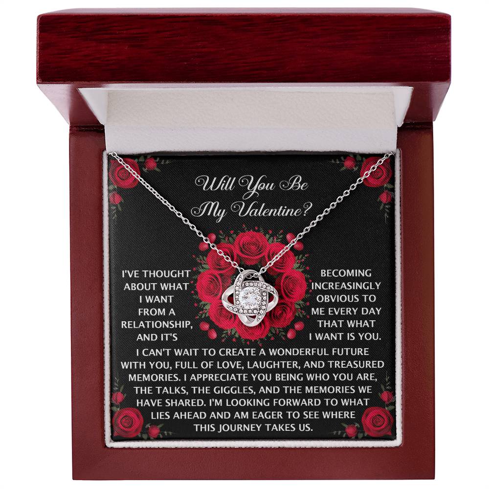 The Soulmate-What I Want - Love Knot Necklace features interlocking hearts and sparkling cubic zirconia, elegantly packaged in a red box with a romantic message and red rose illustrations.