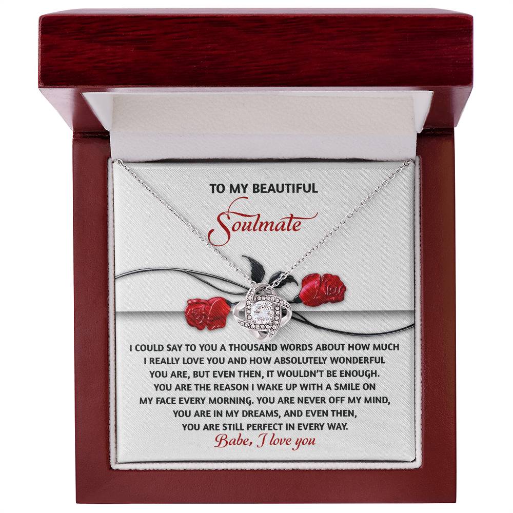 The Soulmate-Every Morning Love Knot Necklace, nestled in a red box adorned with cubic zirconia crystals, features a heartfelt message for a soulmate and is beautifully enhanced by a delicate rose illustration.