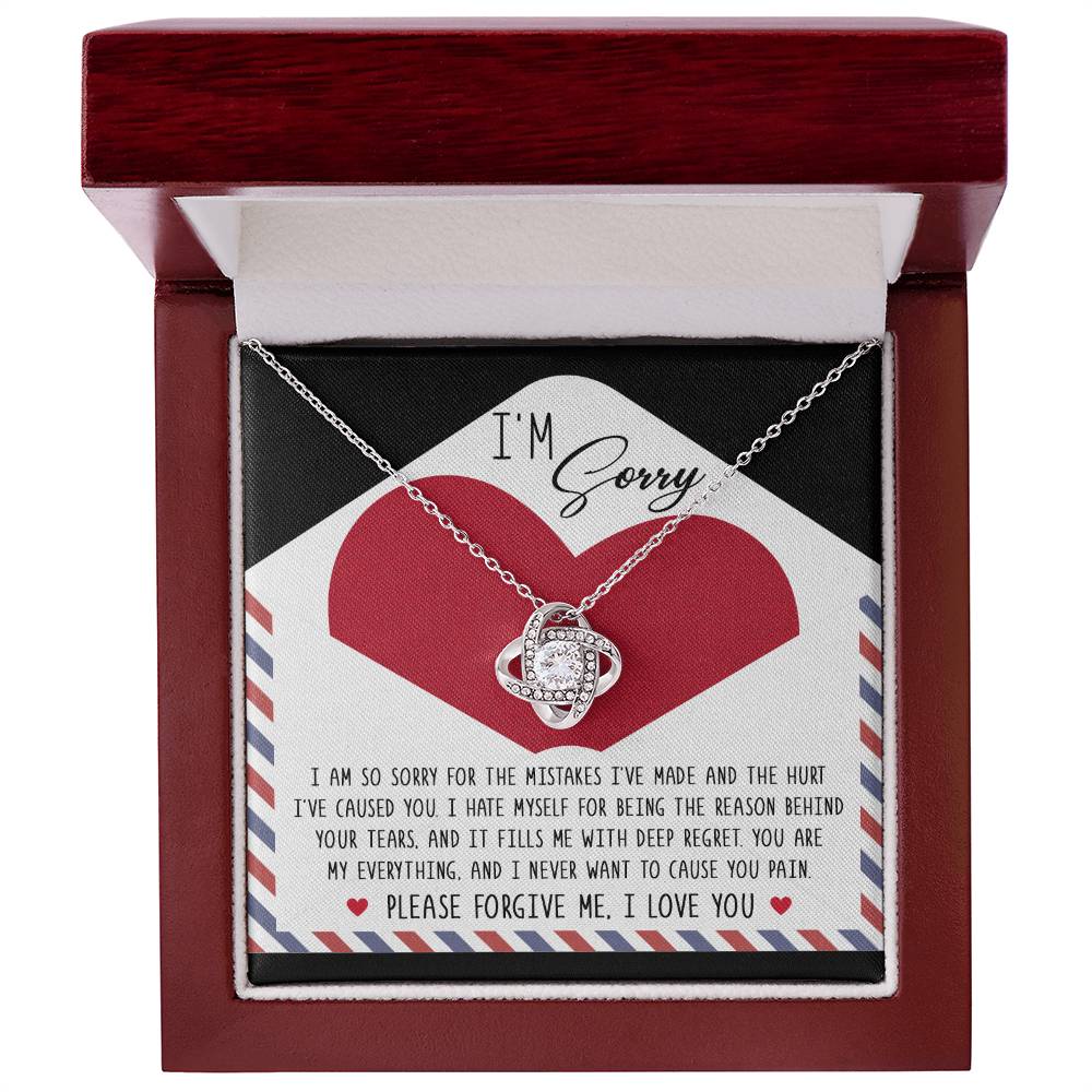 A personalized gift featuring the Sorry-Behind Your Tears - Love Knot Necklace with sparkling cubic zirconia crystals, nestled in a box with a heartfelt note that reads, "I’m Sorry," and an apology message expressing deep regret and asking for forgiveness.