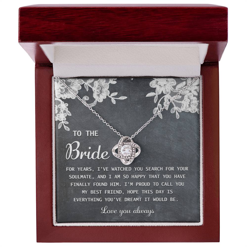 The "To Bride, My Best Friend - Love Knot Necklace" in silver, adorned with cubic zirconia crystals, is presented on a card with a sentimental message for the bride and comes in a decorated gift box.