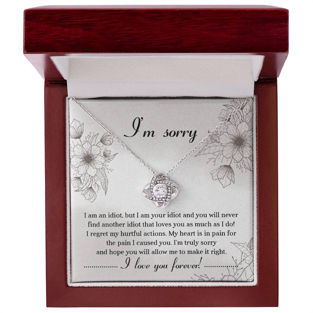 The Sorry-For The Pain - Love Knot Necklace is a personalized gift featuring a love knot pendant adorned with cubic zirconia crystals, presented on a card with an apology message expressing regret and a heartfelt plea for forgiveness, ending with "I love you forever!