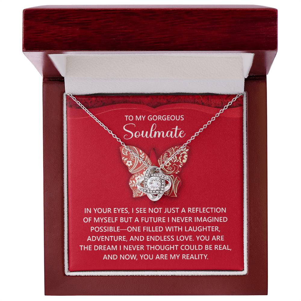 The Soulmate-My Reality - Love Knot Necklace is a personalized gift, elegantly displayed in a red box with a butterfly pendant, sparkling cubic zirconia crystals, and a heartfelt message for your soulmate.