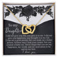The gold "Daughter-Better Person - Interlocking Hearts Necklace" with cubic zirconia crystals rests on a black and white card with decorative black roses, featuring a heartfelt message of love and appreciation for a daughter.
