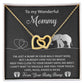 The "To Mama To Be, Until We Meet" necklace is a unique gift featuring interlocking gold hearts with cubic zirconia crystals. It's presented on a heartfelt card adorned with illustrated elephants and hearts, making it a special keepsake for an expecting mother.