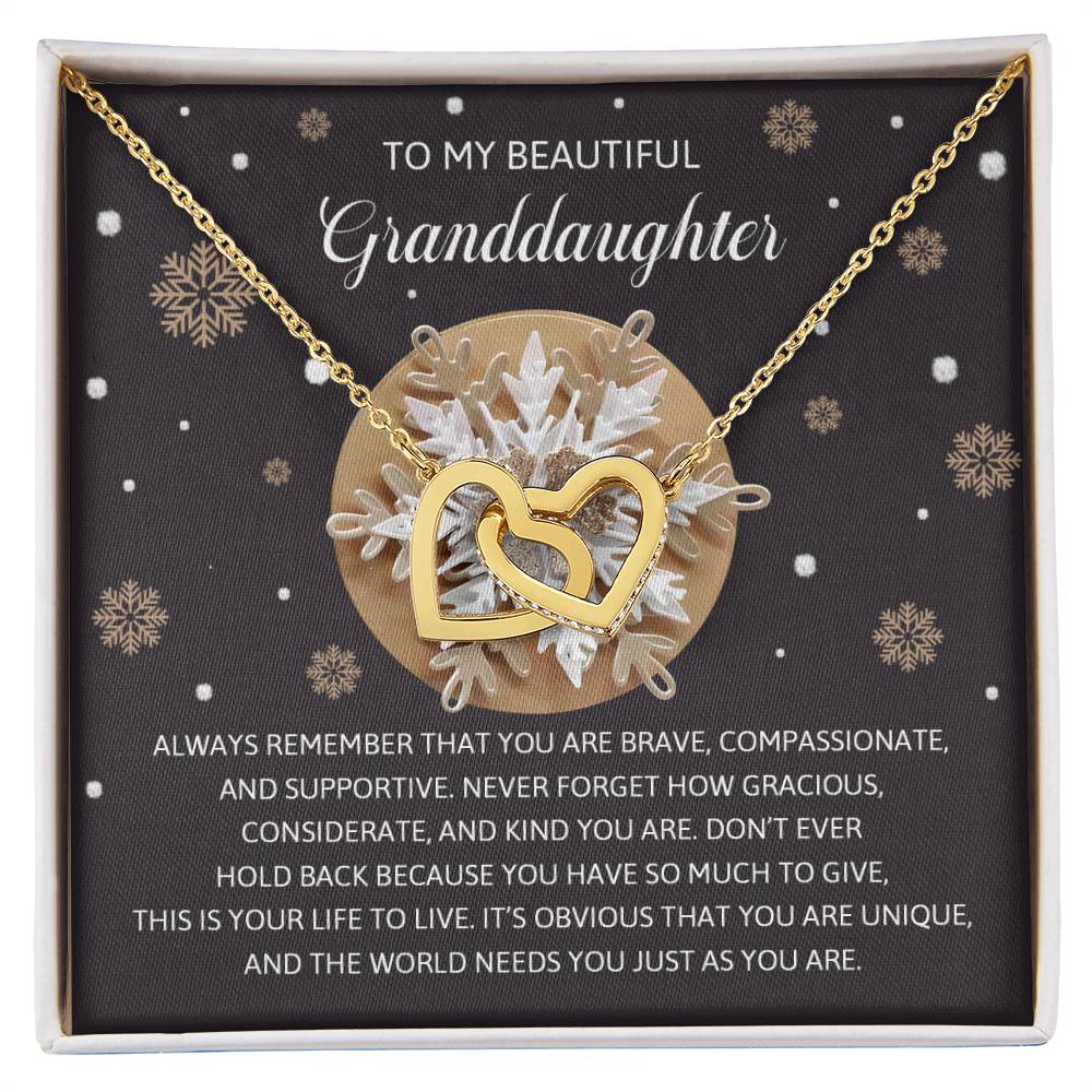 The Granddaughter-As You Are - Interlocking Hearts Necklace boasts a rose gold finish and is elegantly presented on a card featuring an inspiring message for your granddaughter, beautifully adorned with snowflake designs. Its delicate design is further enhanced by sparkling cubic zirconia crystals.