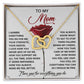 The Mom-Be Fine gift box includes an Interlocking Hearts necklace with gold hearts and cubic zirconia crystals. The lid features a red rose and a heartfelt message to appreciate mothers.