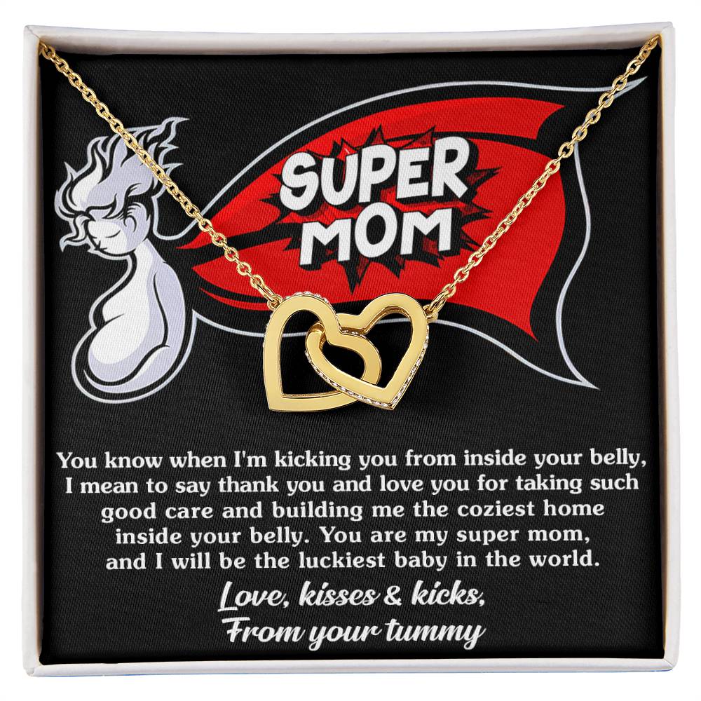 A black fabric square featuring a "super mom" logo with a unicorn, the To Mama To Be, My Super Mom - Interlocking Hearts Necklace from ShineOn Fulfillment, and a sentimental message from an unborn baby to its mother.