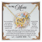The Mom-Taught Me Interlocking Hearts Necklace features cubic zirconia crystals and a heartfelt message to "Mom," expressing gratitude for her love, patience, and sacrifices. The decorative backdrop enhances its beauty, concluding with a touching "I love you.