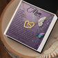 The Mom-Shining Star Interlocking Hearts Necklace, adorned with cubic zirconia crystals, is showcased in an open box against a purple floral backdrop. A heartfelt message to a mother is displayed amid colorful butterflies with "To my Mom" prominently at the top.