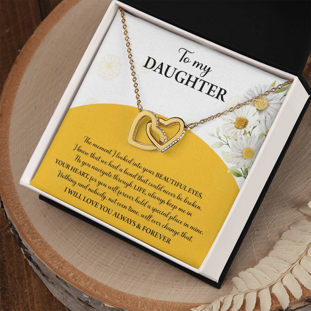 A box contains a "To Daughter, A Special Place - Interlocking Hearts Necklace" with cubic zirconia crystals. The message reads: "To my Daughter... Always keep me in your heart... Nothing brings me more joy than you. I will love you always & forever.