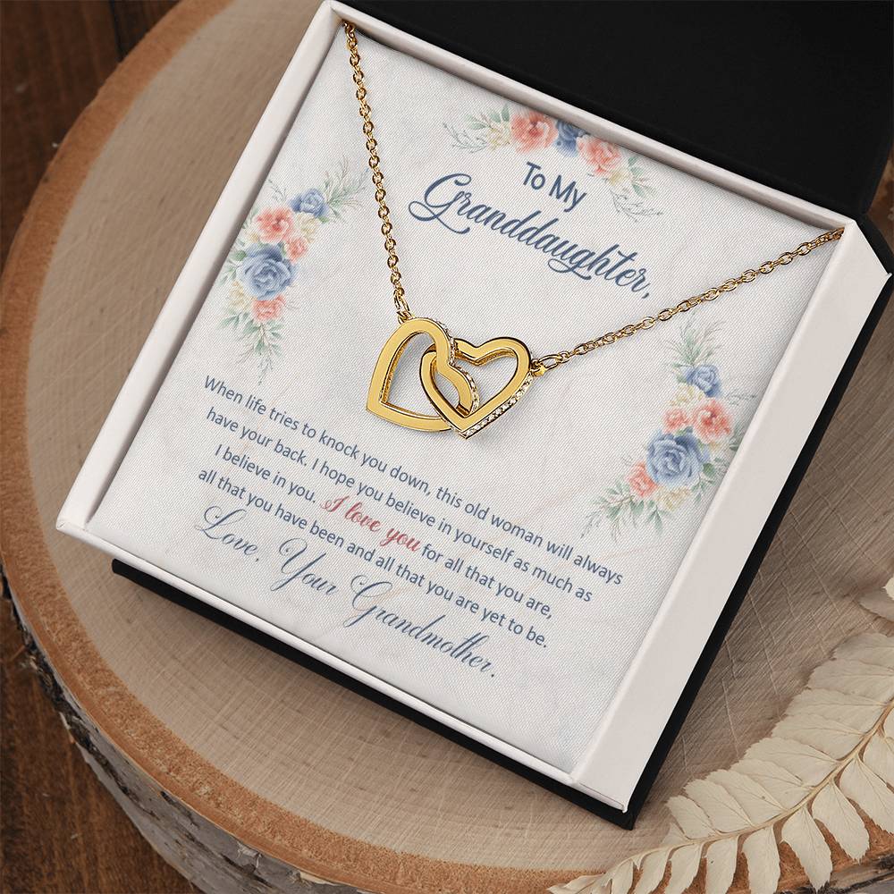 A To My Granddaughter, This Old Woman Will Always Have Your Back - Interlocking Hearts Necklace in a gift box with a sentimental message for a granddaughter from a grandmother, adorned with cubic zirconia crystals by ShineOn Fulfillment.