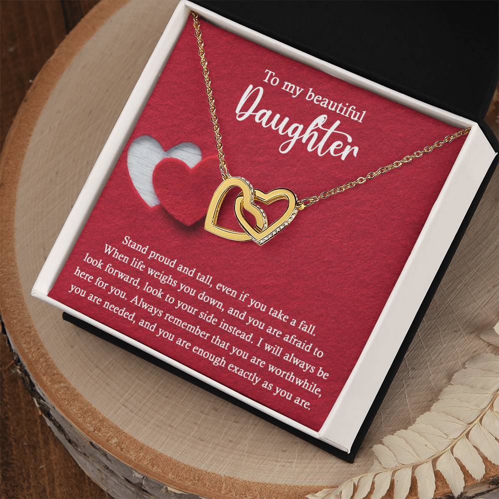 Introducing the elegant "To Daughter, As You Are 2 - Interlocking Hearts Necklace." This stunning piece features two intertwined hearts set against a red background and adorned with sparkling cubic zirconia crystals. The pendant holds the heartfelt message: "To my beautiful Daughter. Stand proud and tall, even if you take a fall..." Crafted from durable surgical steel, this necklace is designed to be both beautiful and enduring.