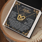 The Mom-God's Masterpiece Interlocking Hearts Necklace gift box showcases intertwined heart pendants. It includes a poetic message titled "God's Masterpiece is Mother," celebrating maternal grace and beauty, elegantly designed with gold accents and a rose gold finish.