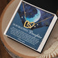 The Daughter-Grown Heart necklace features rose gold-finished interlocking hearts with cubic zirconia crystals. It is presented in a box with a crescent moon and stars, set on wood, and includes a heartfelt message for your daughter on a blue background.