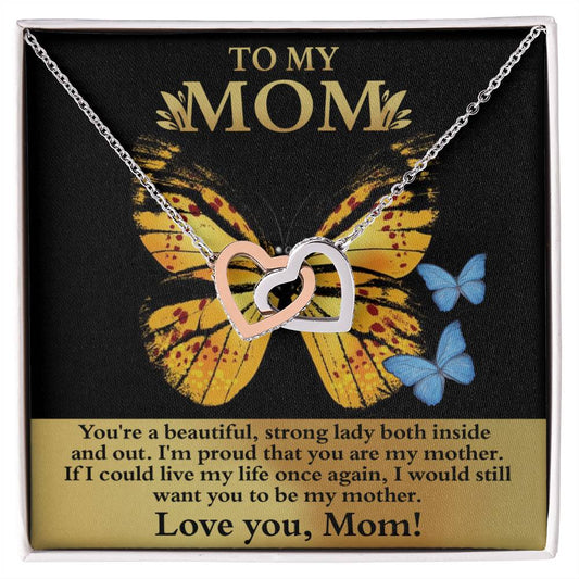 A "To Mom, Strong Lady" necklace with interlocking heart pendants displayed on a card with a butterfly image and a message dedicated to expressing love and admiration.