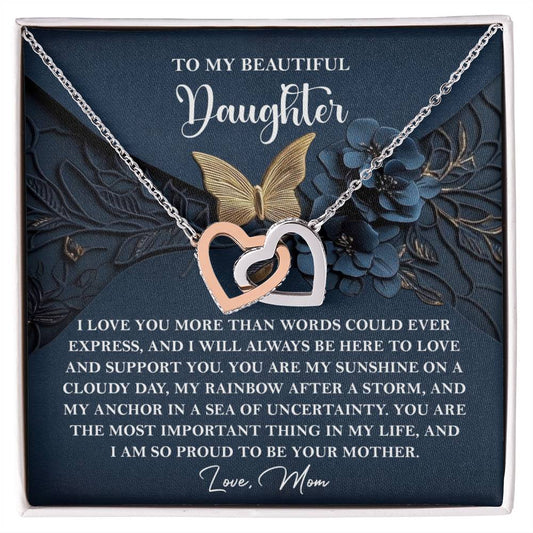 The Daughter-In My Life - Interlocking Hearts Necklace features sparkling cubic zirconia crystals and a rose gold finish, accompanied by a heartfelt note from "Mom" to "Daughter," expressing boundless love and unwavering support.