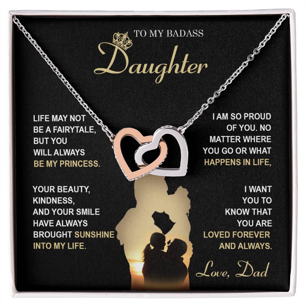 The "To Daughter, Be My Princess - Interlocking Hearts Necklace" with a rose gold finish and adorned with cubic zirconia crystals is displayed in a box that features a heartfelt message from a father to his daughter about love, support, and pride. The text and silhouette of a father and daughter are also included below.