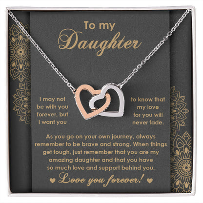 The "To Daughter, Brave And Strong 2 - Interlocking Hearts Necklace" features high-quality polished surgical steel and sparkling cubic zirconia crystals. It is presented on a card adorned with an inspiring message for your daughter, expressing love and encouragement.