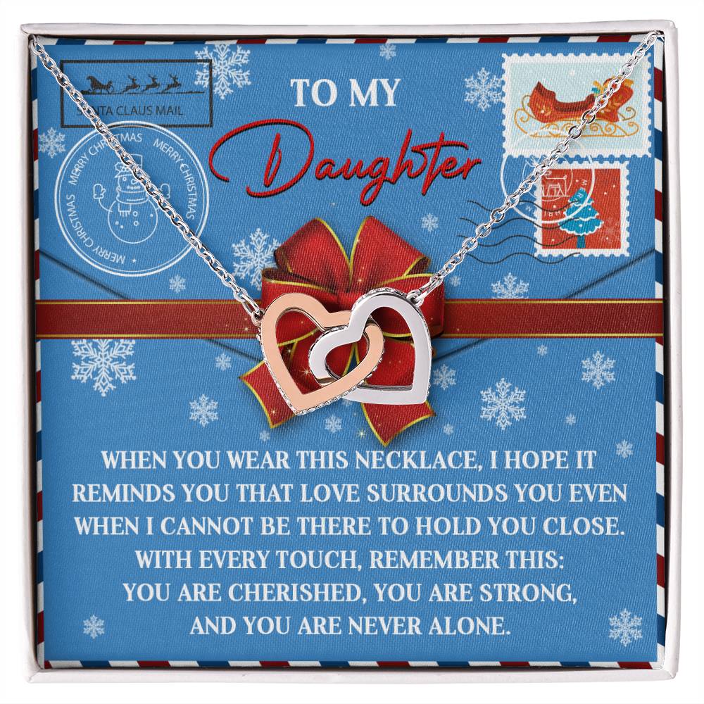 The Daughter-Remember This - Interlocking Hearts Necklace, featuring a rose gold finish and adorned with sparkling cubic zirconia crystals, is elegantly displayed on a decorative card. The card bears a heartfelt message for a daughter, enhanced with holiday-themed stamps and delicate snowflake designs.