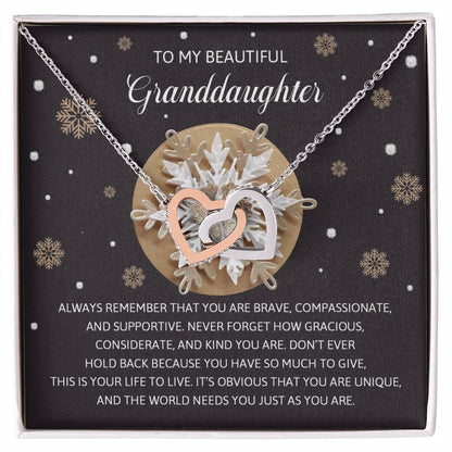 The Granddaughter-As You Are - Interlocking Hearts Necklace, featuring cubic zirconia crystals and a rose gold finish, is presented on a card that includes a heartfelt message to a granddaughter accompanied by delicate snowflake designs.