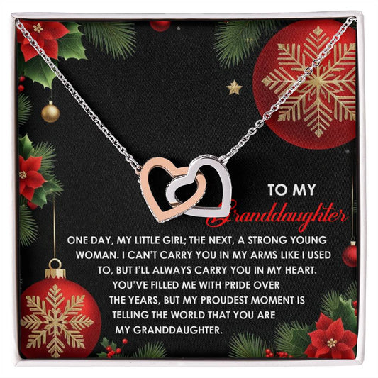 The Granddaughter-Proudest Moment - Interlocking Hearts Necklace, crafted from surgical steel and embellished with cubic zirconia crystals in a beautiful silver and gold design, is elegantly displayed on a holiday-themed card featuring a heartfelt message for your cherished granddaughter.