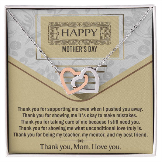 The Mother's Day-Thank You - Interlocking Hearts Necklace, featuring one gold and one silver heart with cubic zirconia crystals, is presented in a “Happy Mother’s Day” box with the message: “Thank you, Mom. I love you.”.