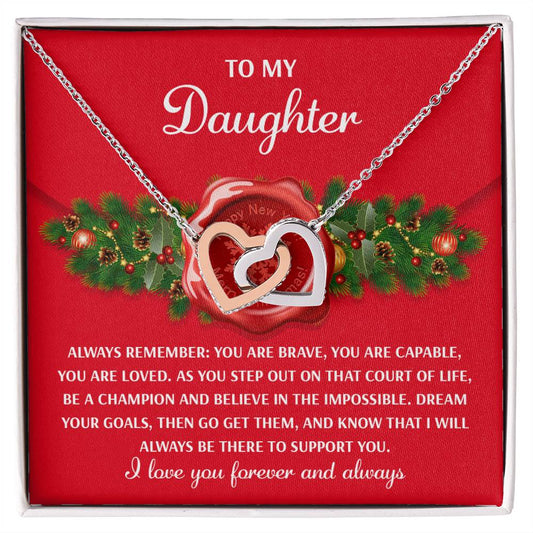 The Daughter-Be A Champion - Interlocking Hearts Necklace, with an elegant rose gold finish and sparkling cubic zirconia crystals, is presented on a card that reads "To my Daughter" and includes an inspiring message against a festive holiday-themed backdrop.