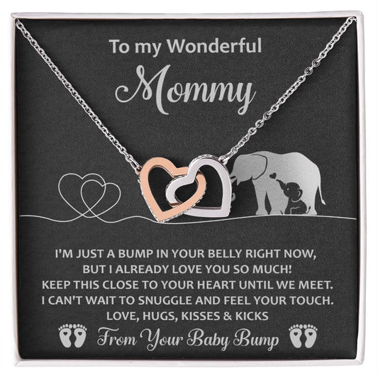 Heart-shaped pendant adorned with cubic zirconia crystals on a chain, displayed on a card with a message from an unborn baby to their mother, featuring elephant graphics and heart designs. The To Mama To Be, Until We Meet - Interlocking Hearts Necklace.